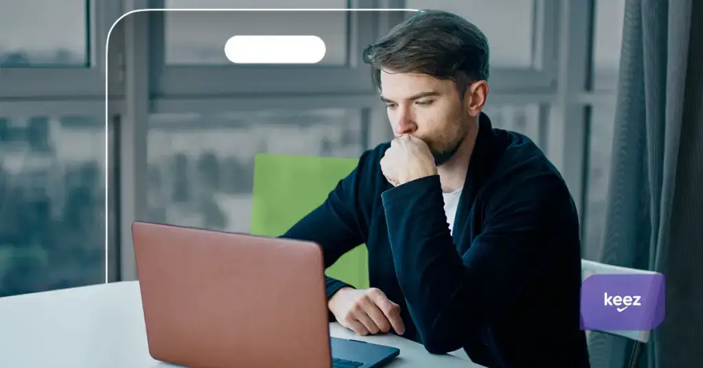 Barbat care se uita ingandurat la laptop