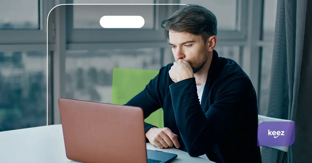 Barbat care se uita ingandurat la laptop
